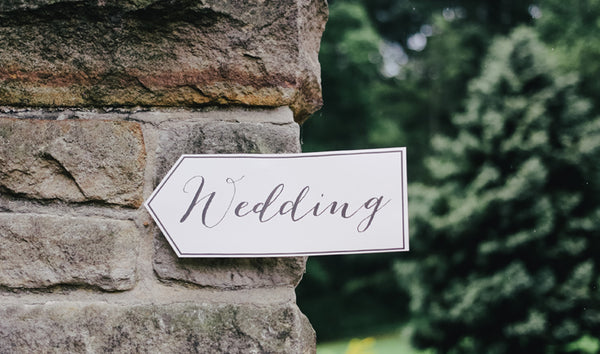 A white arrow sign with wedding written on. Read our blog post on keeping children and toddlers at weddings entertained. 